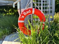 Ein Schwimmring hängt an einem Treppengeländer.