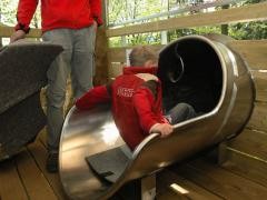 Ein Kind steigt in die Riesenröhrenrutsche.