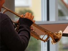 Ein Kind spielt auf einer Trompete.