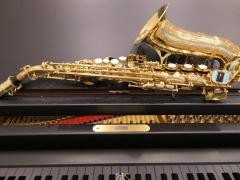 Ein Saxophon liegt auf einem Flügel.