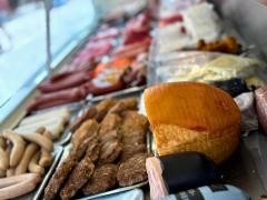 Verschiedene Wurstwaren liegen in der Auslage eines Marktstands.