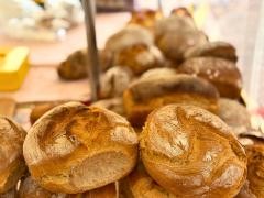 Mehrere Brot liegen auf einem Marktstand.
