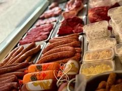 Verschiedene Wurstwaren liegen in der Auslage eines Marktstands.