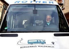 Ein Mann sitzt in einem Bus auf dem Fahrersitz. Auf der Motorhaube steht "Bürgerbus Waldkirch"