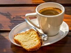 Eine Tasse Kaffee und ein Stück Kuchen stehen auf einem Tisch