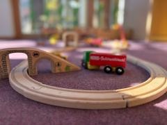 Eine Holzeisenbahn ist auf dem Boden aufgebaut.