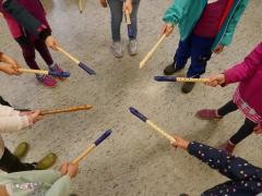 Viele kleine Kinder halten ihre Blockflöten als Stern zusammen.