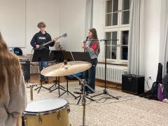 Ein paar Kinder spielen Musikinstrumente.