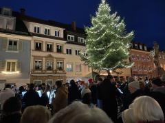 Auf dem Waldkircher Marktplatz steht ein Tannenbaum. Davor stehen viele Menschen.