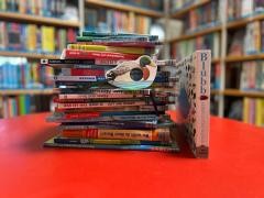 Auf einem roten Tisch sind verschiedene Bücher zum Thema Wasser gestapelt.