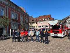 Vertreter der lokalen BOS-Dienste stehen vor ihren Fahrzeugen auf dem Marktplatz