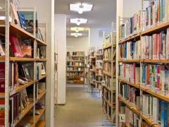 Innenansicht der Mediathek. Rechts und links eines Gangs stehen Bücherregale.